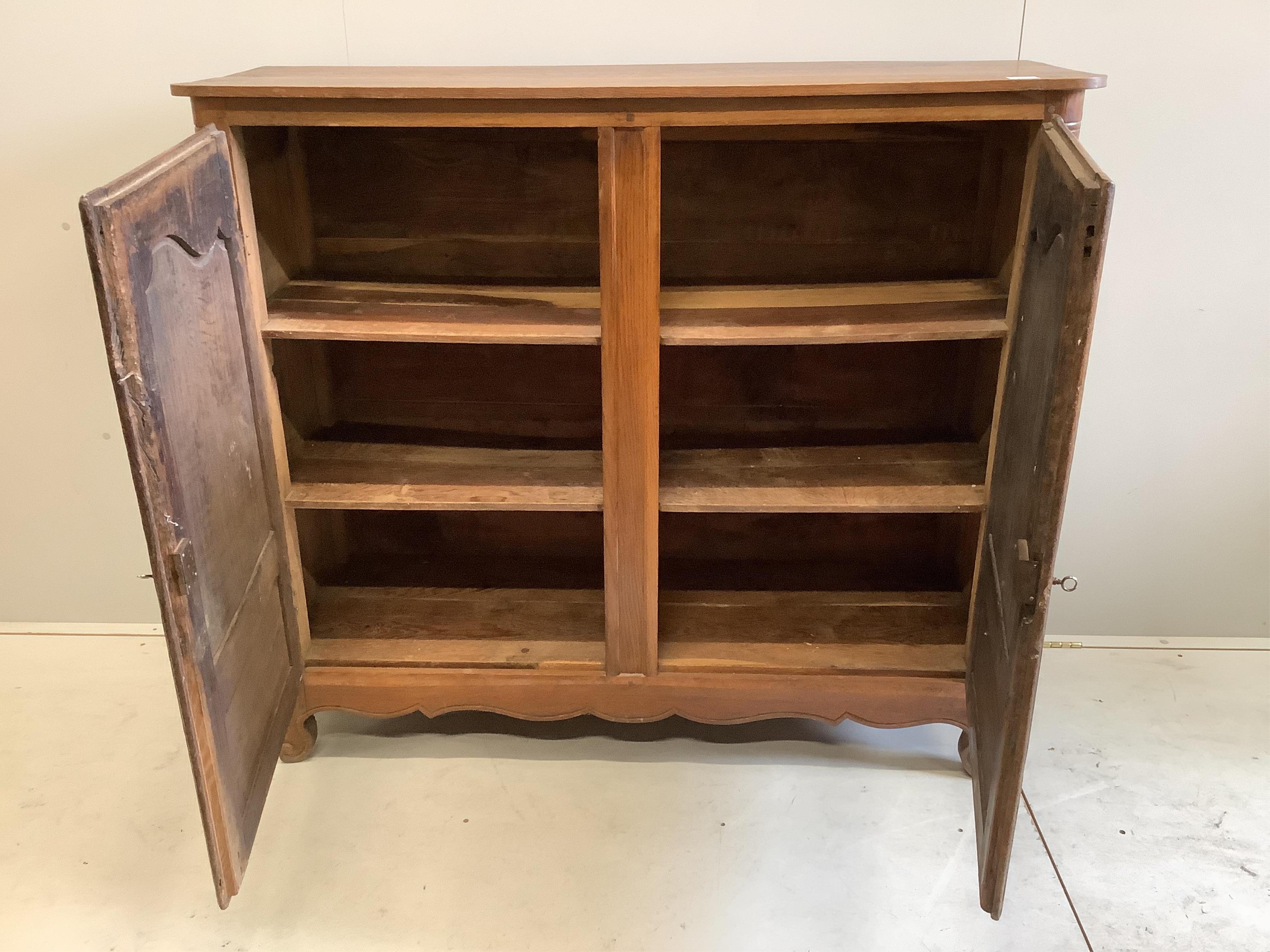 An 18th century French oak two door cupboard, width 134cm, depth 46cm, height 118cm